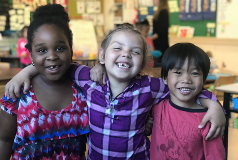 Three primary students smiling